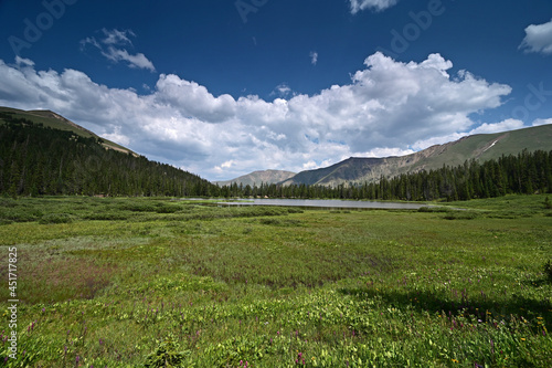 Hassell Lake in Arapaho National Forest, Colorado on sunny summer afternoon under extensive cloudscape.