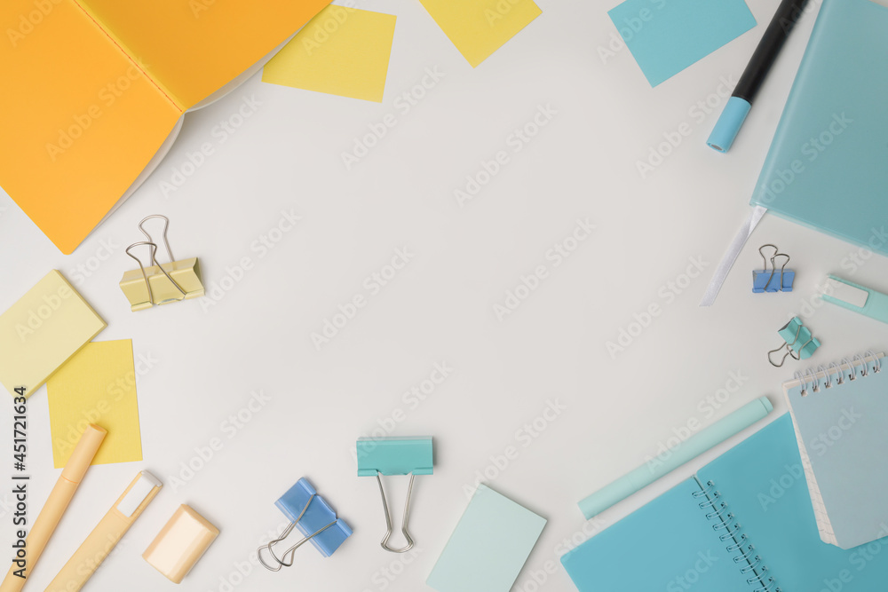 Top view colorful notebooks and stationery on white background.