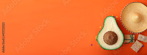 Pinata in shape of avocado, sombrero and gifts on color background with space for text