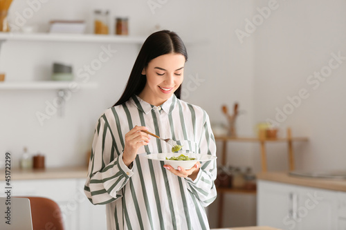 Beautiful young woman eatin...