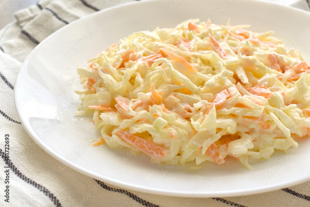 Coleslaw salad with carrot and cabbage on a white plate. Coleslaw salad with carrot and cabbage on a white plate.