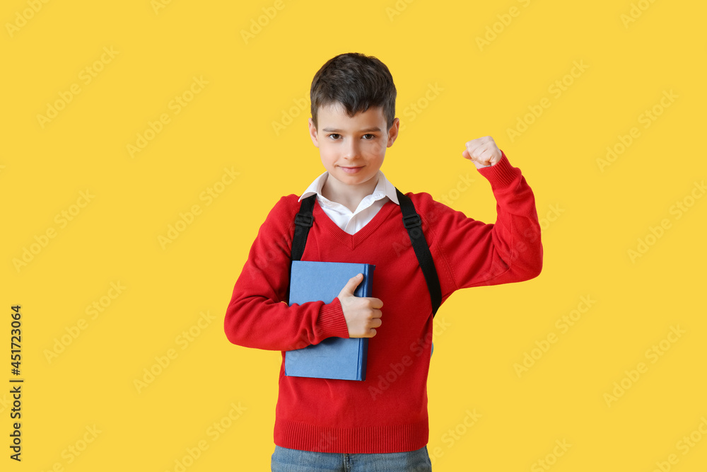 Little schoolboy with book on color background Little schoolboy with book on color background