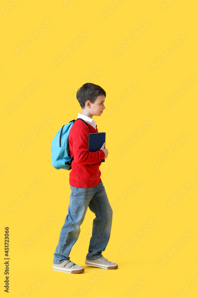 Little schoolboy with book on color background Little schoolboy with book on color background