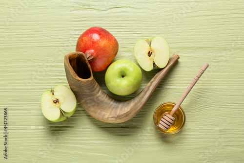 Honey with fruits and shofar on color wooden background. Rosh hashanah (Jewish New Year) celebration