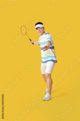 Sporty male badminton player on color background © Pixel-Shot