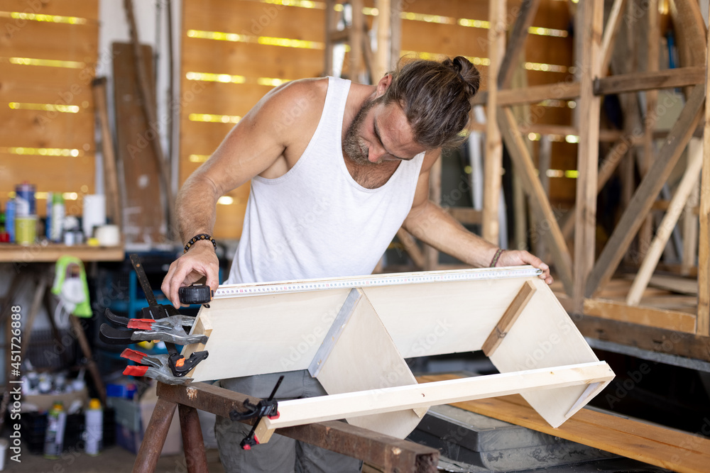 Man constructing a small cupboard for a caravan