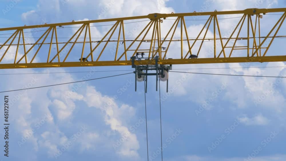 Big yellow crane moving a load along its jib Big yellow crane moving a load along its jib