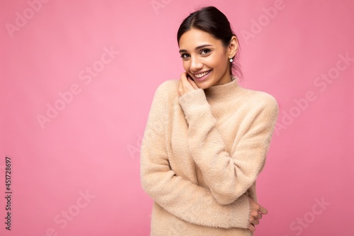 Photo of young positive happy smiling beautiful woman with sincere emotions wearing stylish clothes isolated over background with copy space