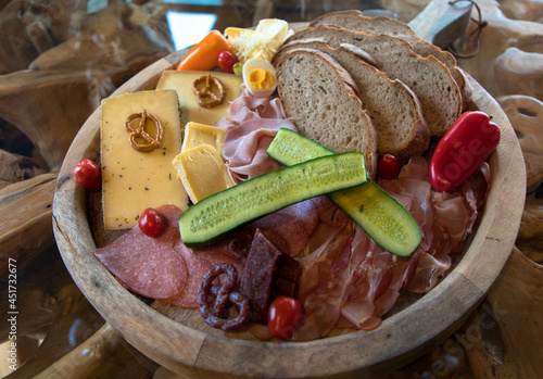 Delicious sausage and cheese plate perfectly garnished and cooked on a wooden board