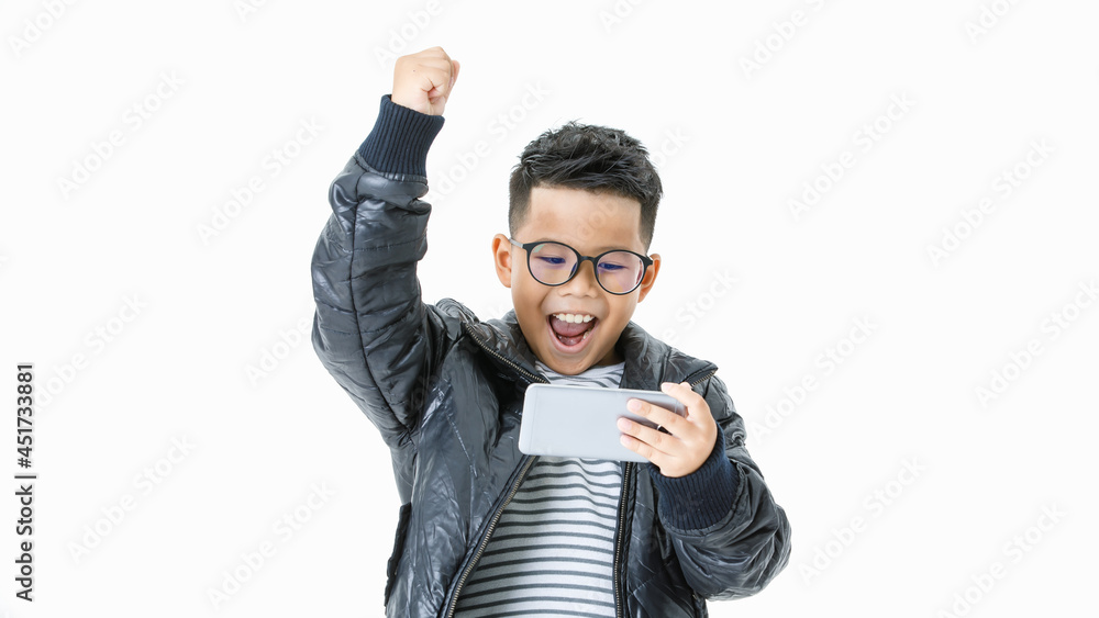 Cutout portrait of lively Asian boy on casual black jacket looking at mobile phone and happily shouting out and raising hand up as mission completed, task accomplished and win online game play Cutout portrait of lively Asian boy on casual black jacket looking at mobile phone and happily shouting out and raising hand up as mission completed, task accomplished and win online game play