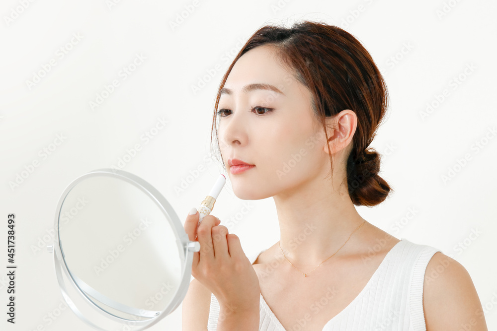 鏡を見ながら口紅を塗っている女性の横顔