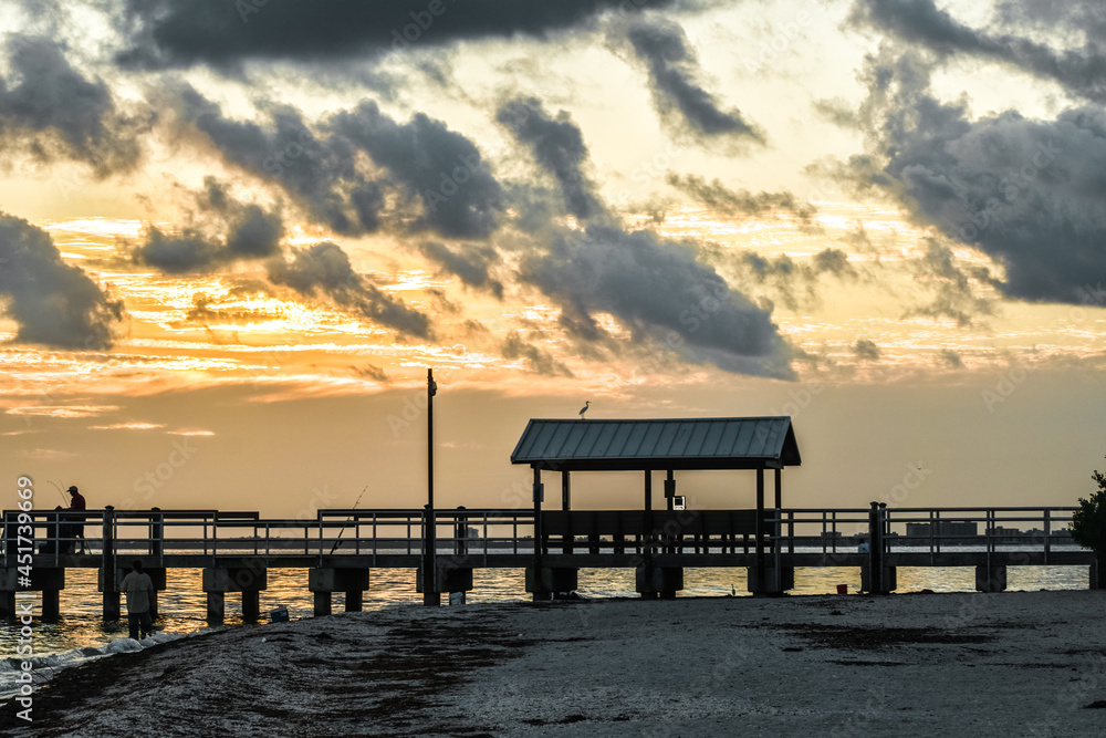 sunset at Sanibel lighthouse park where people are fishing on a dock