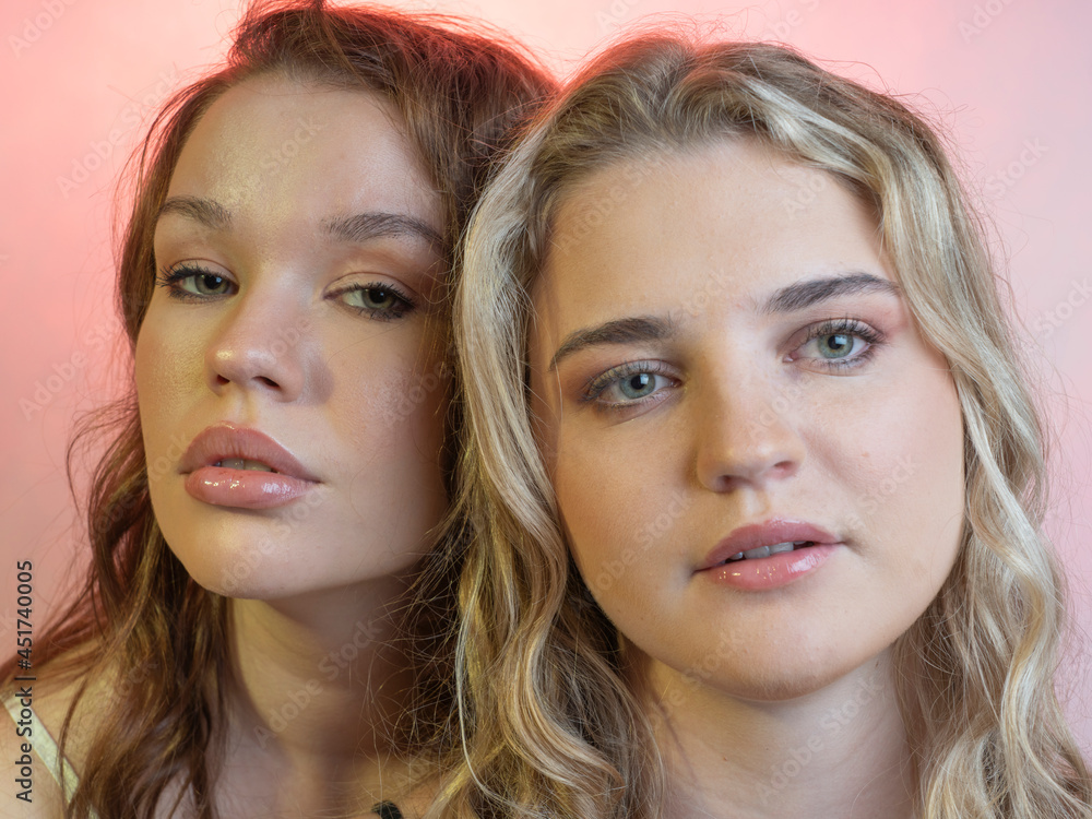 Portrait of two.girlfriends. Close-up . In a studio . on a pink background. Portrait of two.girlfriends. Close-up . In a studio . on a pink background.