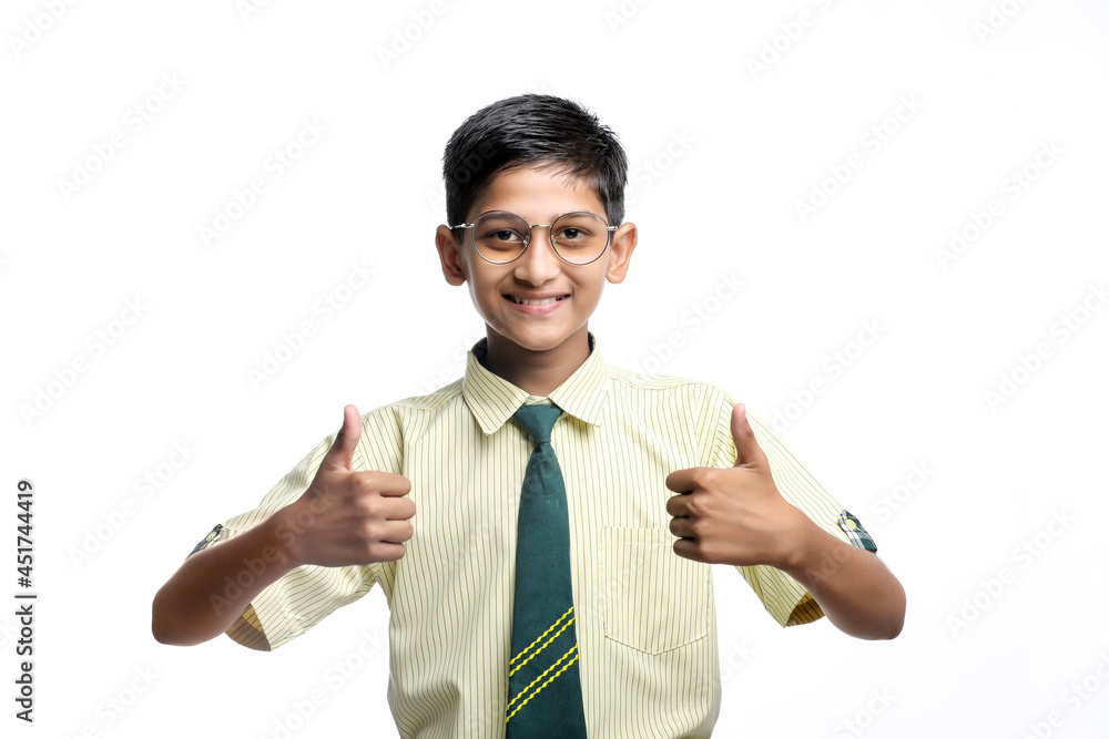 Indian child in school uniform and showing thumps up on white background. Indian child in school uniform and showing thumps up on white background.