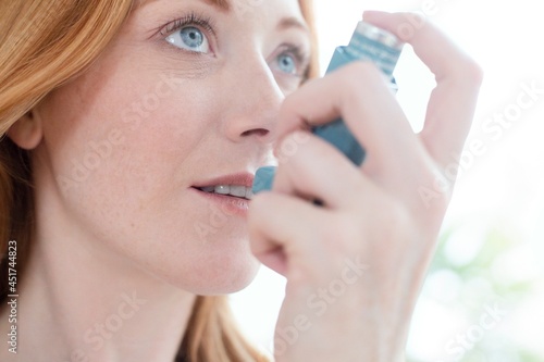 Woman using inhaler photo