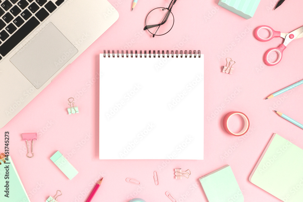 Blank notepad mockup. Top view of laptop and stationery on a pink pastel background. Workspace concept. Blank notepad mockup. Top view of laptop and stationery on a pink pastel background. Workspace concept.
