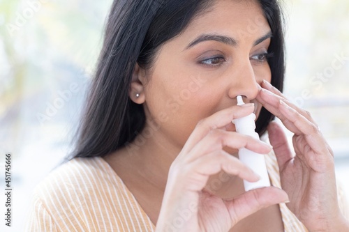 Woman using a nasal spray photo