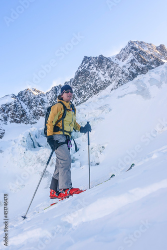Junge Extremsportlerin steilen Aufstieg mit Skiern im vergletscherten Hochgebirge