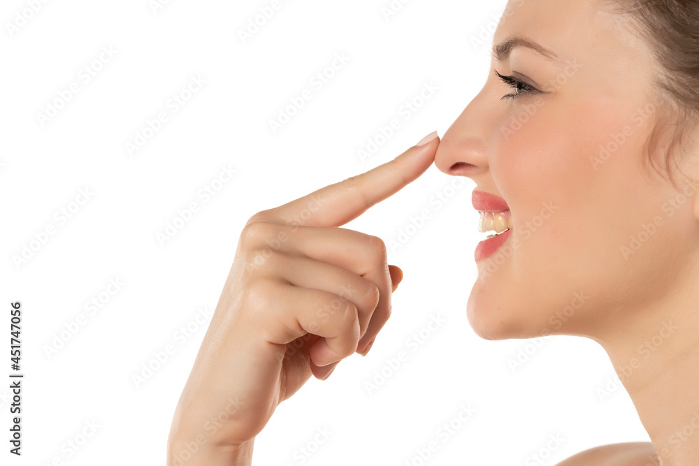profile of a blonde smiling woman touching her nose profile of a blonde smiling woman touching her nose