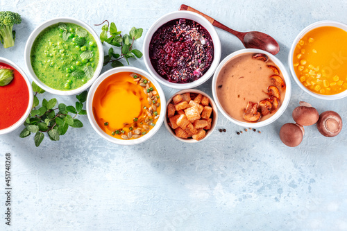 Vegan soups, fresh summer detox diet, overhead flat lay shot with copy space. Green soup, beetroot, mushroom, pumpkin and others