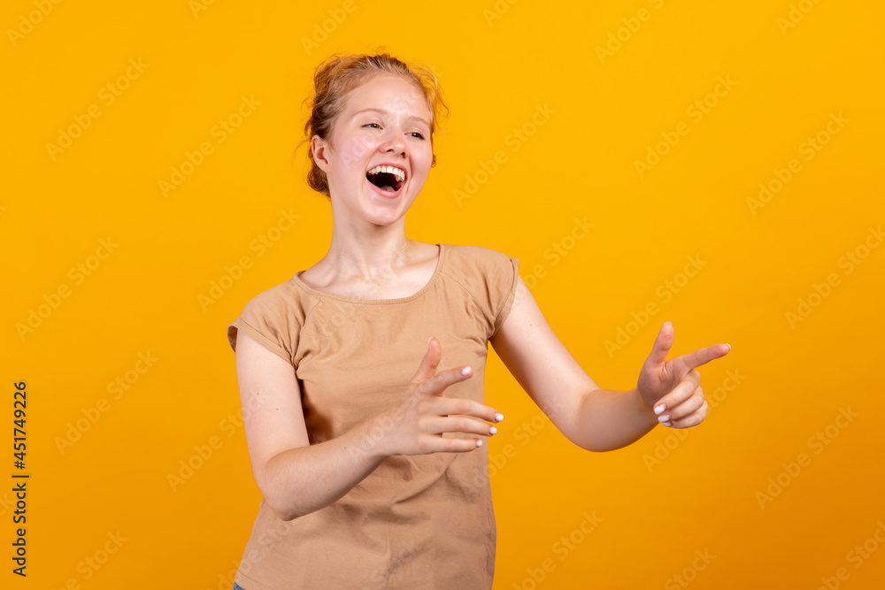 Horizontal portrait of young laughing girl isolated on yellow studio background. Concept of human emotions, facial expression, youth, sales, ad. Horizontal portrait of young laughing girl isolated on yellow studio background. Concept of human emotions, facial expression, youth, sales, ad.