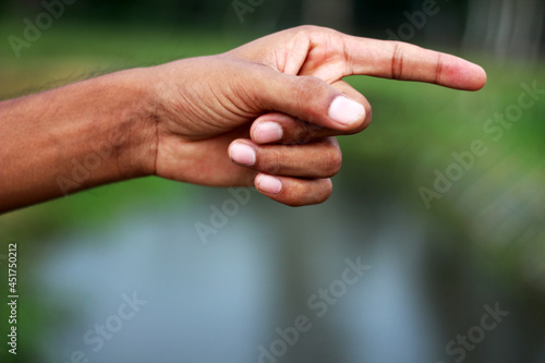 A human hand and a finger pointing to one side And the Background blur © Rokonuzzamnan