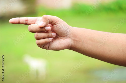 A fat human hand and a finger pointing to one side And the Background blur © Rokonuzzamnan