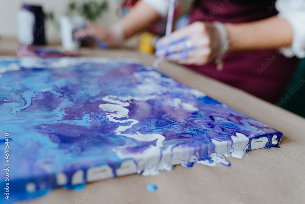 Fototapeta premium Artist mixing acryl paints on the picture working in fluid art technique
