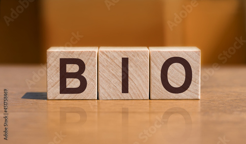 BIO text on wooden cubes on orange wall background.