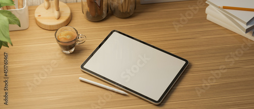 tablet blank screen mockup on wooden table and decorations