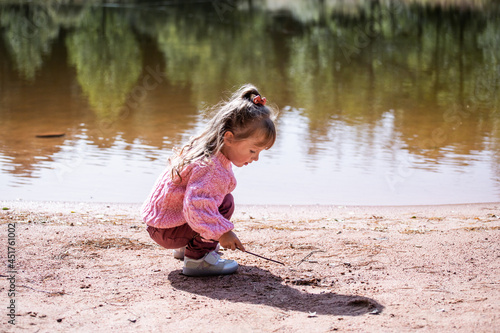 little girl playing near the pond © Liubov Kartashova