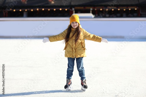 Cute little girl at outdoor ice skating rink