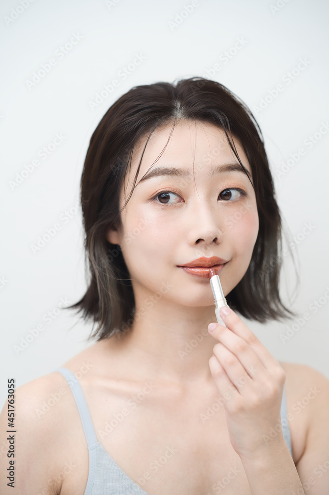 口紅を唇に塗る若い女性 口紅を唇に塗る若い女性