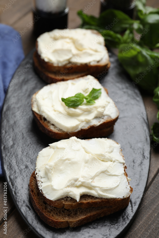 Bread with cream cheese on wooden table Bread with cream cheese on wooden table