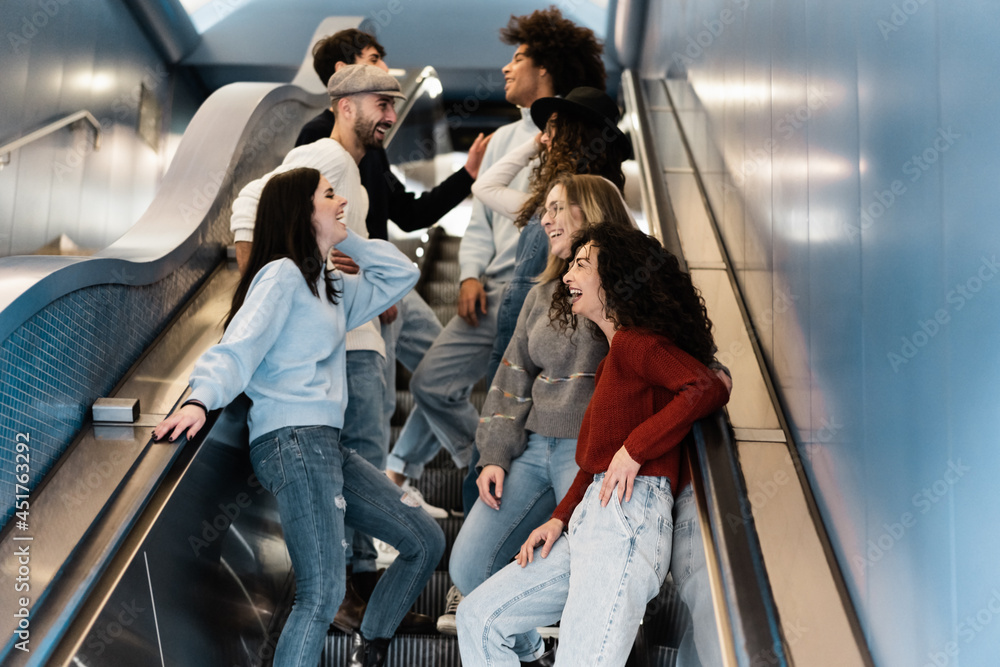 Happy group of friends having fun together on subway metro stairs - Focus on bottom right girl