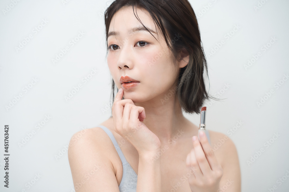口紅を唇に塗る若い女性 口紅を唇に塗る若い女性
