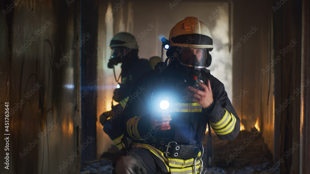 Firemen examining hallway after fire Firemen examining hallway after fire