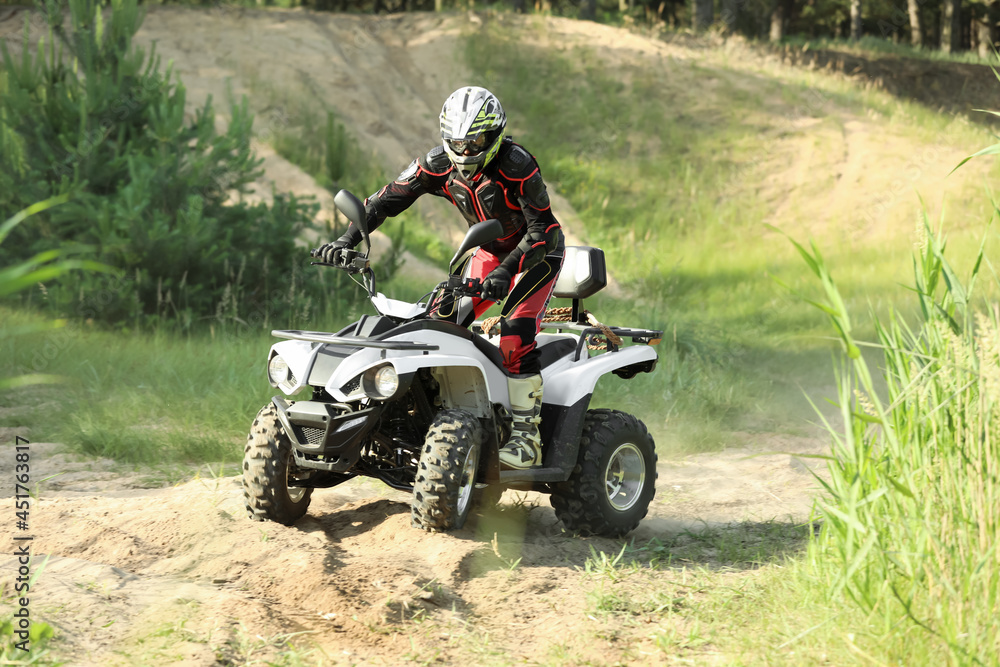 Man driving modern quad bike on sandy road. Extreme sport Man driving modern quad bike on sandy road. Extreme sport