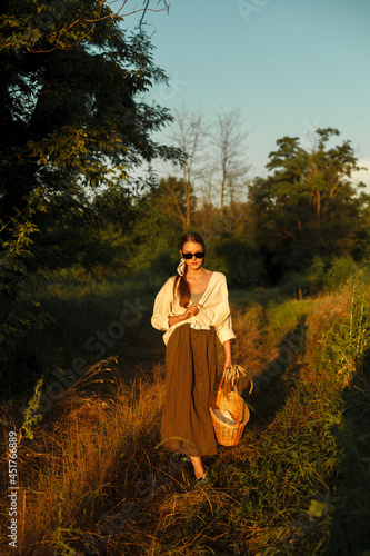 stylish girl in glasses with a full-length basket goes