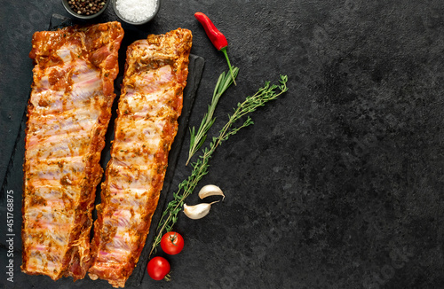 raw pork ribs marinated with spices on a stone background with copy space for your text