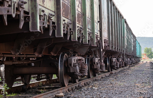 Old rusty railway cars stand on the tracks of the station