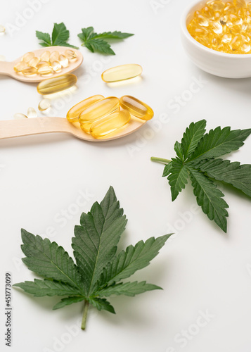 CBD oil with cannabis leaf and seeds in a wooden spoon, viewed from directly above