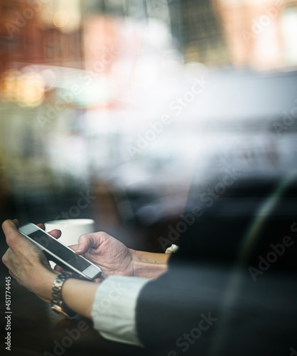 Businesswoman using a phone in a cafe