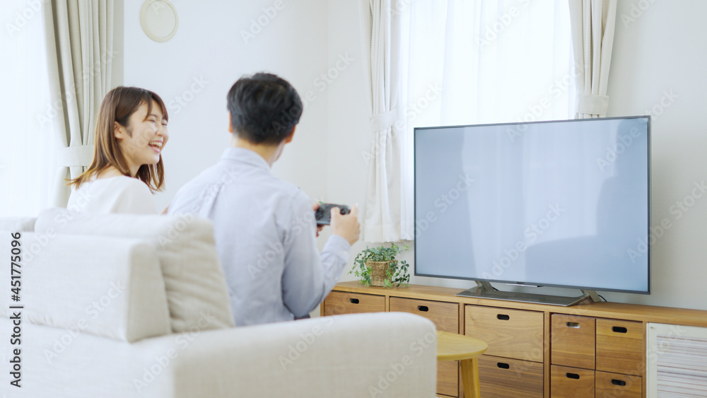 家でテレビゲームをする夫婦・カップル 家でテレビゲームをする夫婦・カップル