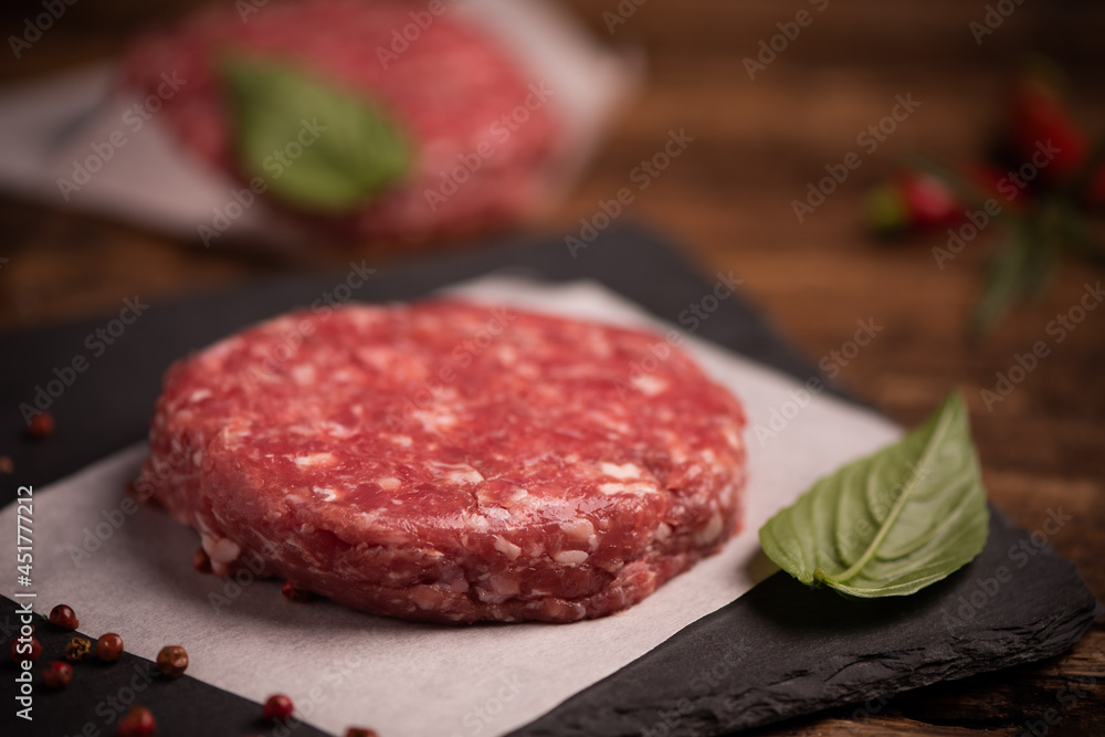 Raw ground beef meat burger steak cutlets on wooden background Raw ground beef meat burger steak cutlets on wooden background