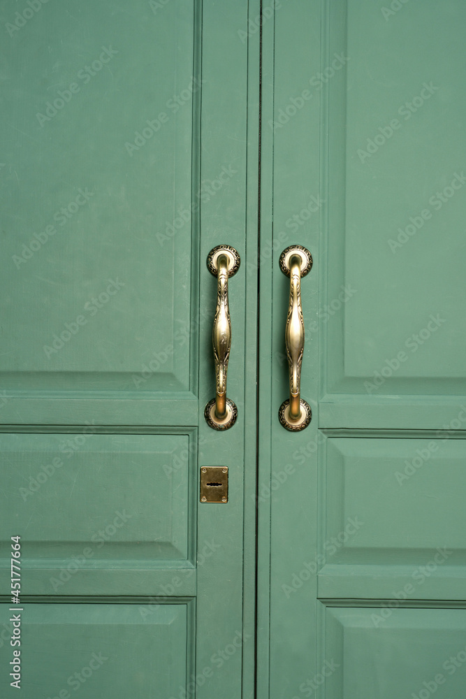 old wooden doors close up. antique gold door handles old wooden doors close up. antique gold door handles