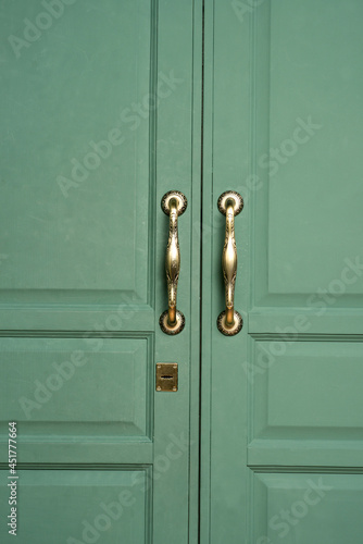 old wooden doors close up. antique gold door handles