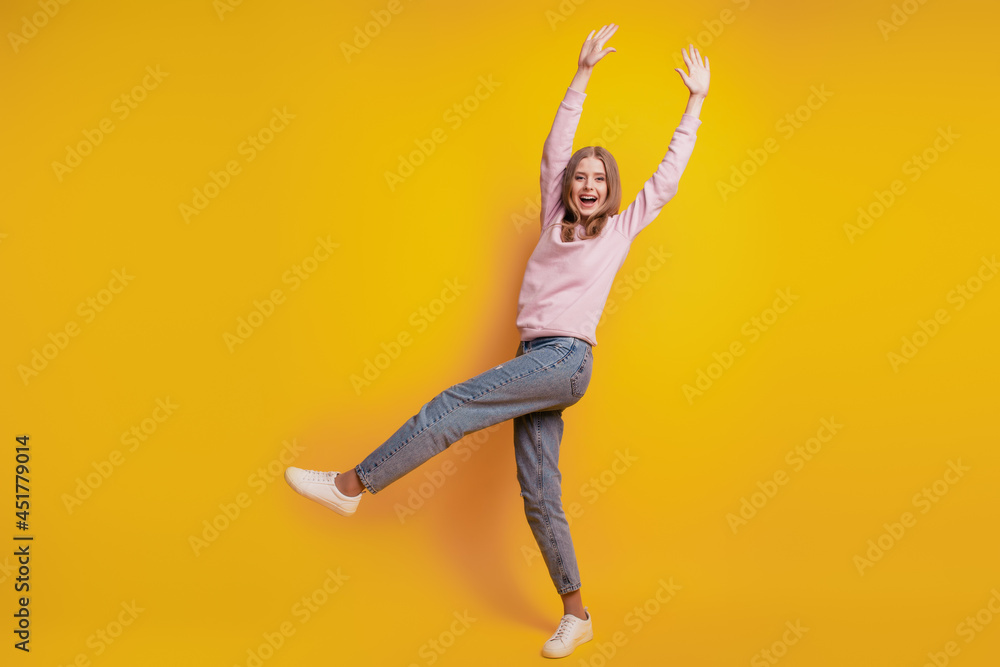 Photo of positive girl stand one leg have fun on yellow background