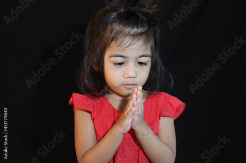 Asian Little cute Girl Holding Hand and Praying .