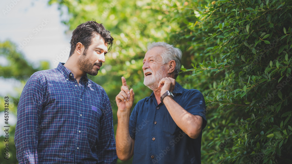 Fototapeta premium Adult hipster son and old senior father stay for work at home, two generations have a beard talking together and relaxing with smile, happy enjoy living to isolation quarantine at home, father's day